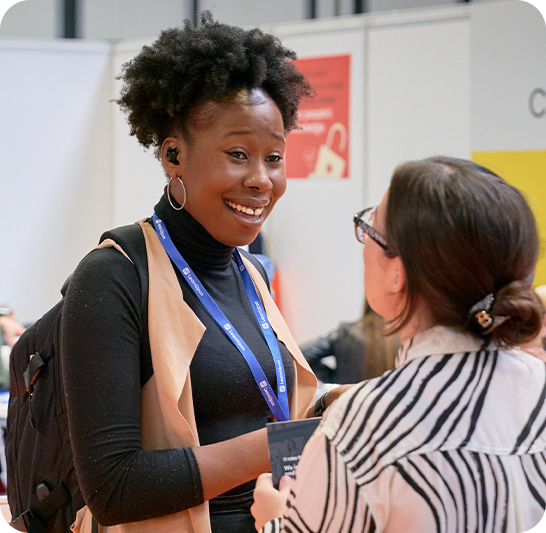 woman smiling as she speaks to another woman